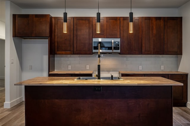 kitchen with light hardwood / wood-style flooring, decorative light fixtures, and butcher block countertops