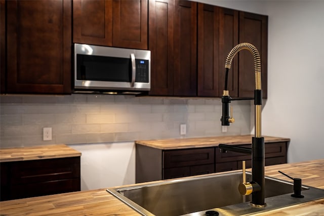 kitchen with tasteful backsplash and butcher block counters