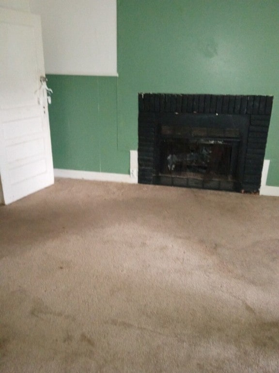 unfurnished living room featuring a fireplace and carpet