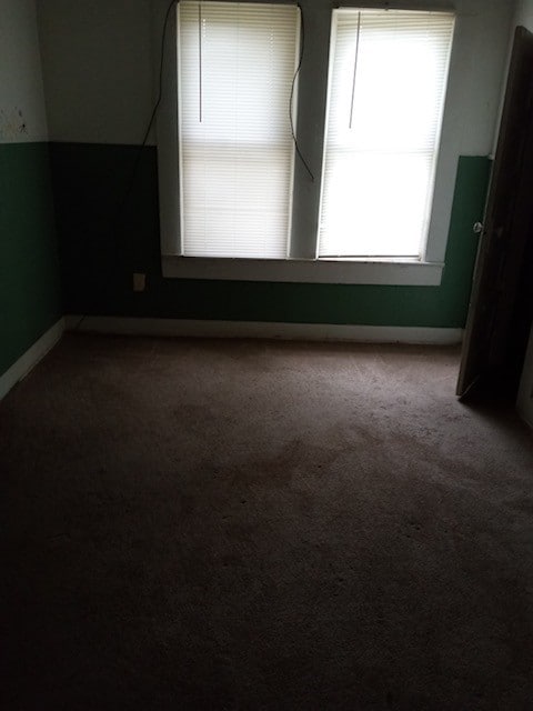 unfurnished room featuring dark carpet