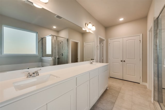 bathroom with dual sinks, oversized vanity, plus walk in shower, and tile floors