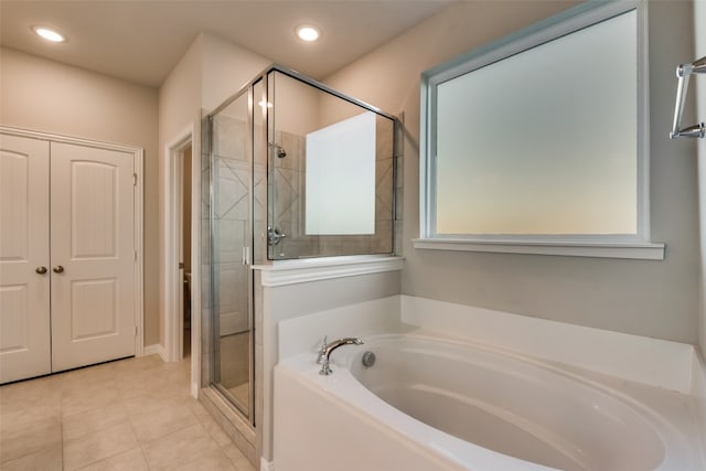 bathroom featuring shower with separate bathtub and tile floors