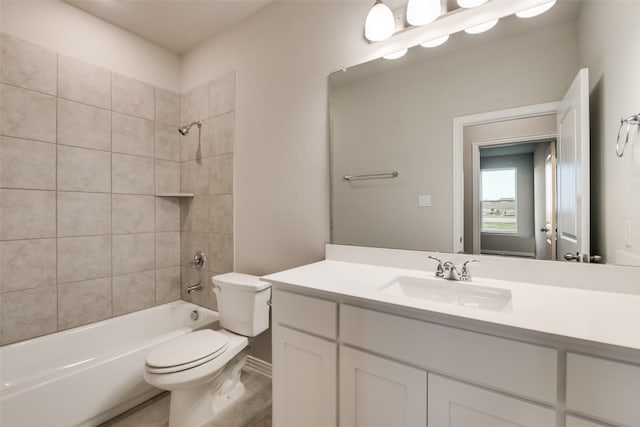 full bathroom featuring tiled shower / bath combo, oversized vanity, and toilet