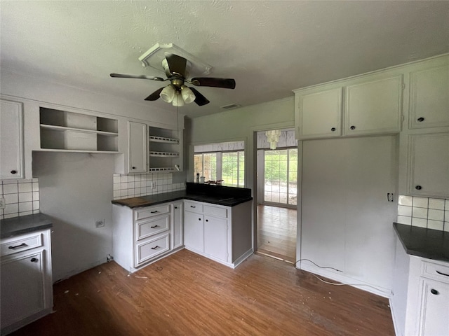 kitchen with backsplash, dark hardwood / wood-style floors, white cabinets, and ceiling fan