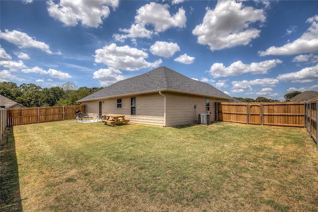 rear view of house featuring a yard and central AC unit