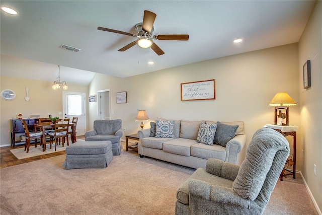 living room featuring light carpet, vaulted ceiling, and ceiling fan with notable chandelier