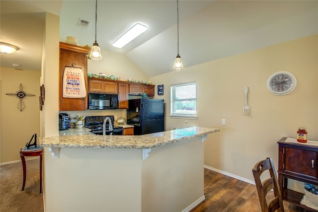 kitchen featuring kitchen peninsula, pendant lighting, a kitchen breakfast bar, dark colored carpet, and black appliances