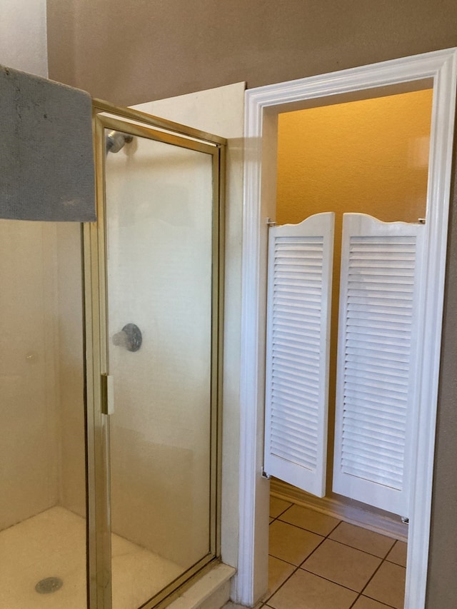 bathroom featuring tile patterned flooring and a shower with door