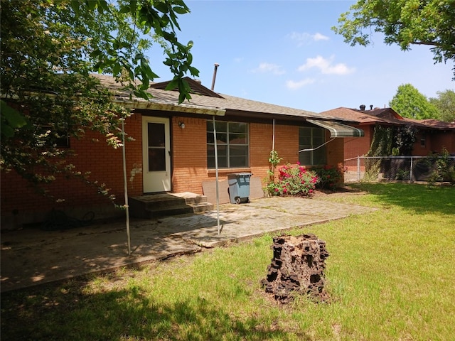 rear view of house with a yard and a patio area