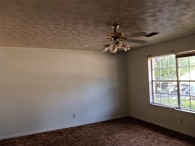 unfurnished room with dark colored carpet and ceiling fan