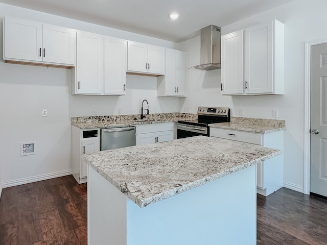 kitchen featuring dark wood-type flooring, wall chimney exhaust hood, appliances with stainless steel finishes, white cabinetry, and sink