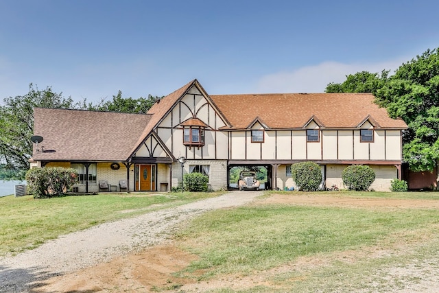 tudor home with central air condition unit and a front yard