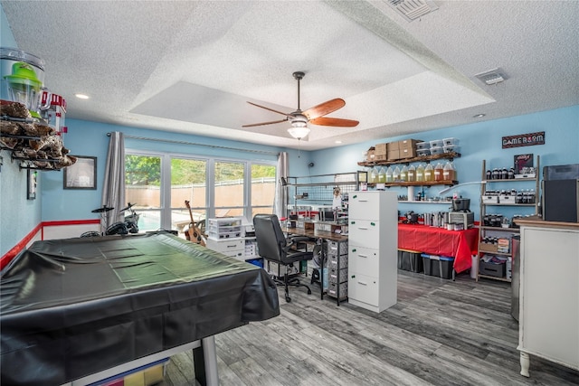 recreation room with hardwood / wood-style floors, ceiling fan, billiards, a textured ceiling, and a tray ceiling