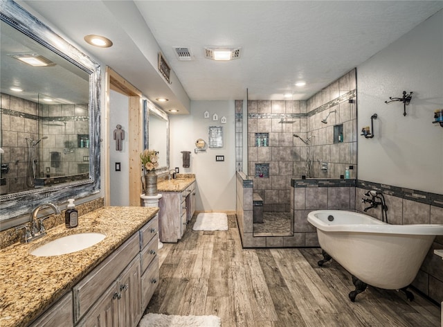 bathroom with tile walls, vanity, independent shower and bath, and wood-type flooring