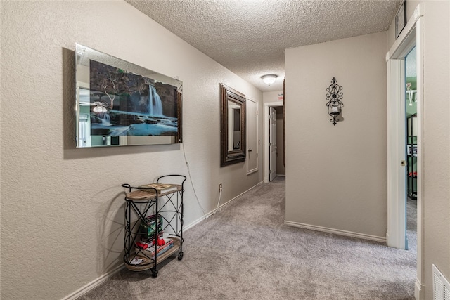 corridor featuring light carpet and a textured ceiling