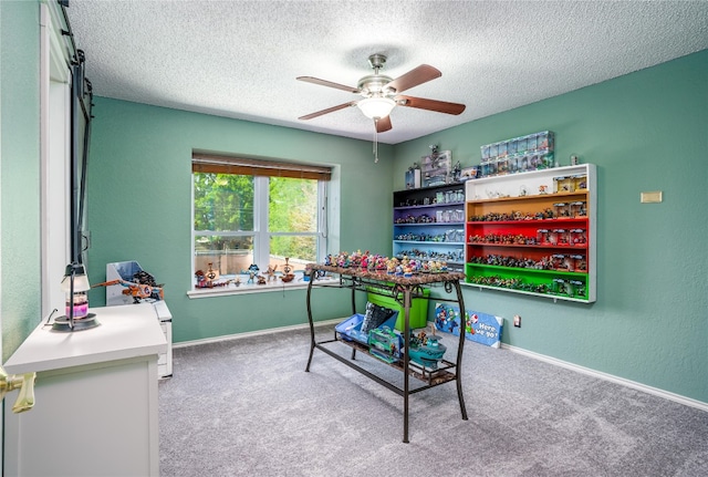 game room featuring ceiling fan, a textured ceiling, and light carpet