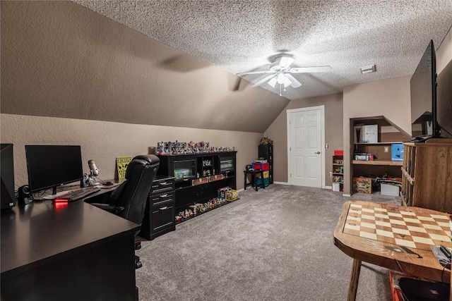 carpeted office with vaulted ceiling, ceiling fan, and a textured ceiling