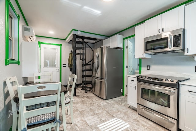 kitchen with a wall mounted air conditioner, crown molding, stainless steel appliances, light tile flooring, and white cabinetry