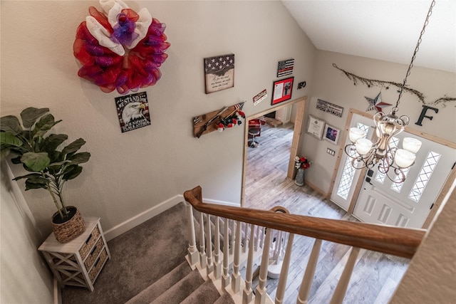 stairs with dark hardwood / wood-style flooring and a notable chandelier