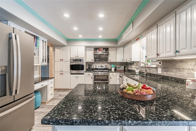 kitchen featuring sink, dark stone counters, white cabinets, stainless steel appliances, and tasteful backsplash