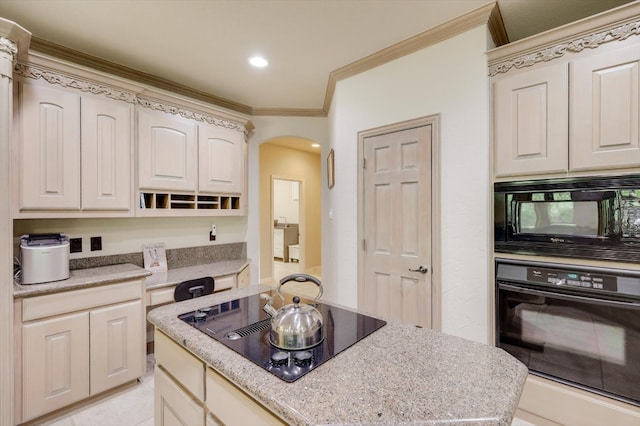 kitchen with light stone counters, crown molding, and black appliances