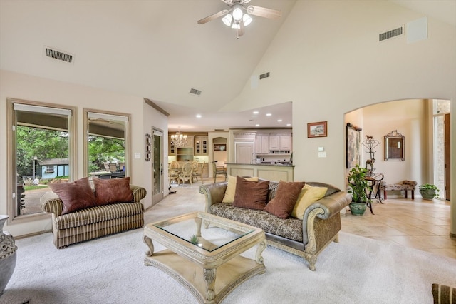 living room with sink, high vaulted ceiling, light tile patterned flooring, and ceiling fan with notable chandelier