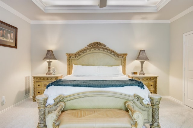 carpeted bedroom with a tray ceiling and ornamental molding