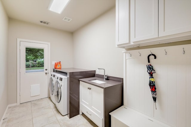 laundry room with cabinets, light tile patterned floors, sink, and independent washer and dryer