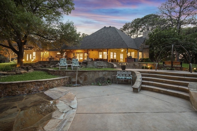 back house at dusk with a patio