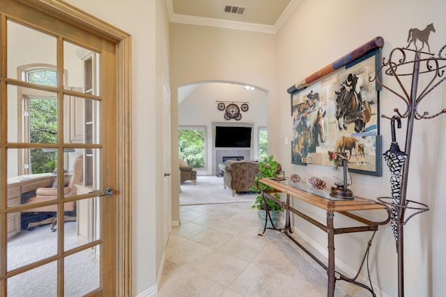 hall with light tile patterned floors and ornamental molding