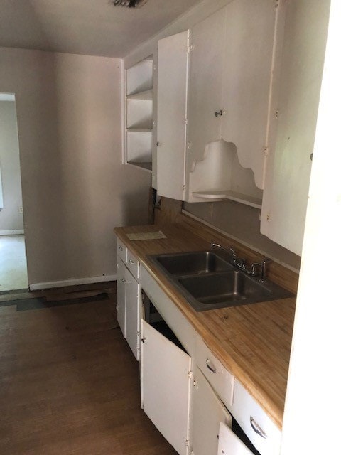 kitchen with sink, dark hardwood / wood-style floors, and white cabinets