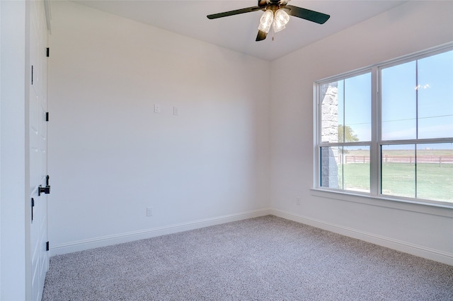 carpeted spare room featuring ceiling fan