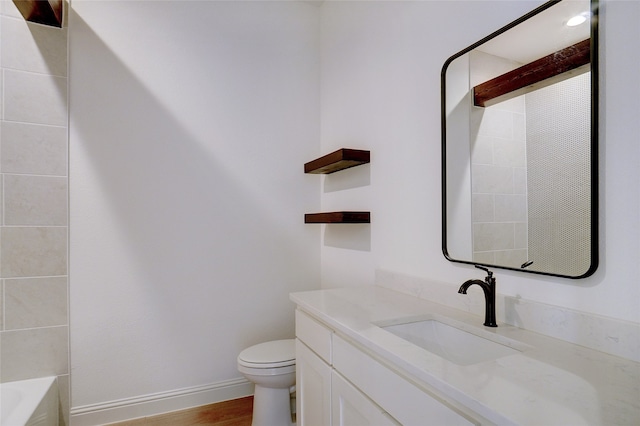 full bathroom featuring vanity, tiled shower / bath, toilet, and wood-type flooring