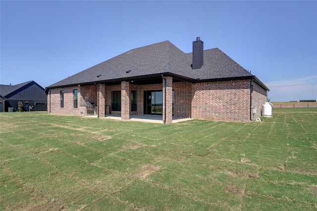 back of house featuring a patio area and a lawn