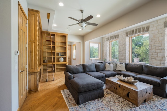 living room with ceiling fan and light hardwood / wood-style flooring