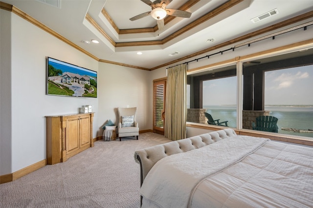 bedroom with a water view, ceiling fan, a raised ceiling, light colored carpet, and ornamental molding