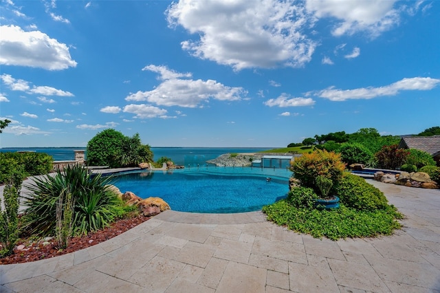 view of swimming pool featuring a patio and a water view