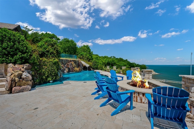 view of patio featuring an outdoor fire pit and a water view