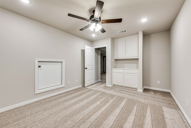 unfurnished bedroom with light colored carpet and ceiling fan