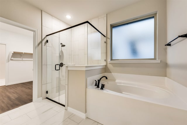 bathroom featuring hardwood / wood-style floors and independent shower and bath