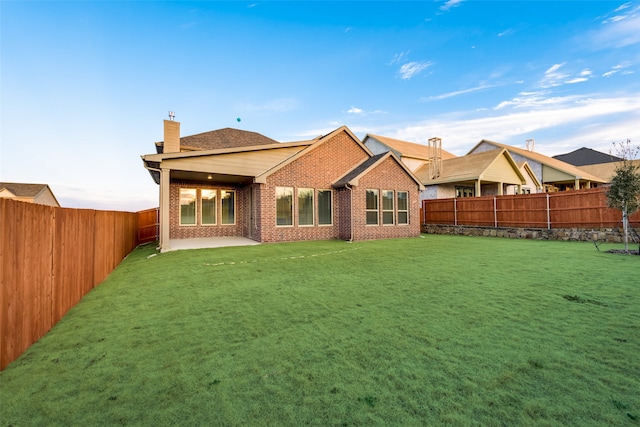 back of property with a yard and a patio area