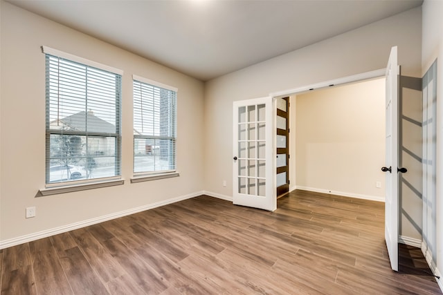 spare room featuring wood-type flooring and french doors