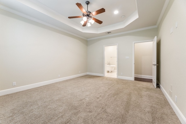 unfurnished bedroom featuring light colored carpet, ensuite bathroom, a raised ceiling, and ceiling fan