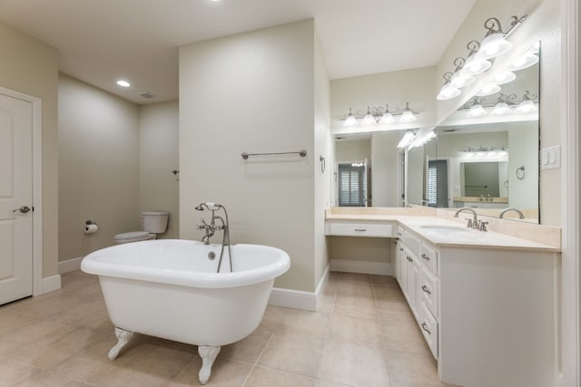 bathroom featuring a bath, tile floors, vanity with extensive cabinet space, and toilet