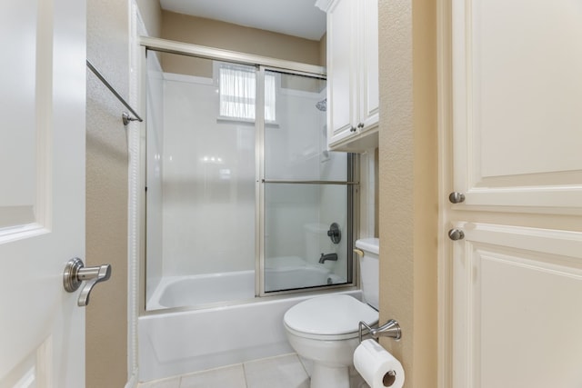 bathroom featuring shower / bath combination with glass door, tile floors, and toilet