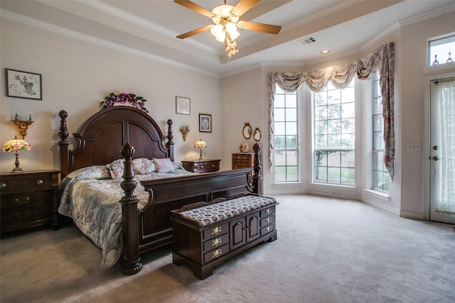 carpeted bedroom featuring access to exterior, a raised ceiling, ornamental molding, and ceiling fan