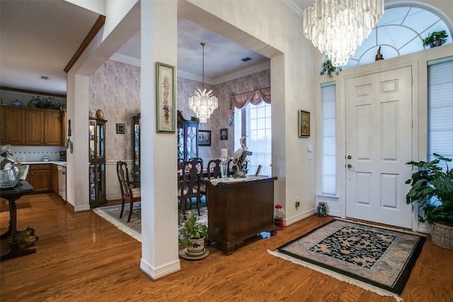 foyer featuring crown molding, dark hardwood / wood-style floors, and an inviting chandelier