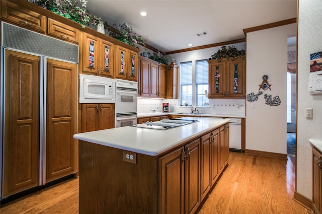 kitchen featuring light hardwood / wood-style flooring, built in appliances, a center island, and sink