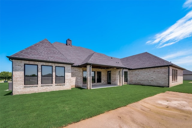 rear view of property featuring a patio area and a yard