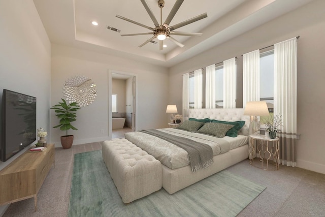 bedroom featuring ensuite bathroom, a raised ceiling, and ceiling fan